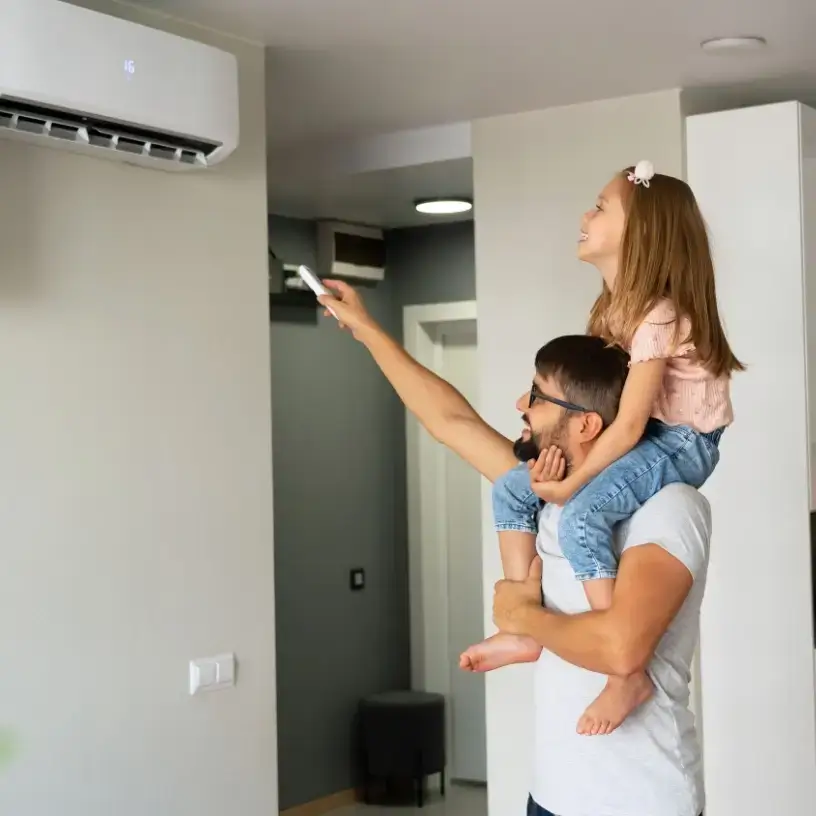 Father and daughter adjusting aircon settings